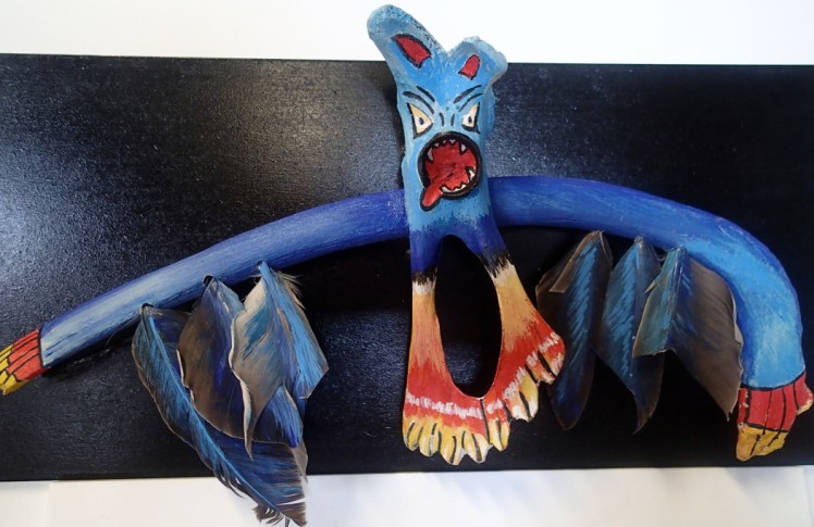 Titre : Tupilak Dimensions : 21x 43cm Matériaux : plume d’aigle, os de phoque Technique : peinture acrylique, collage, sculpture Origine : Groenland Année de réalisation : 2016